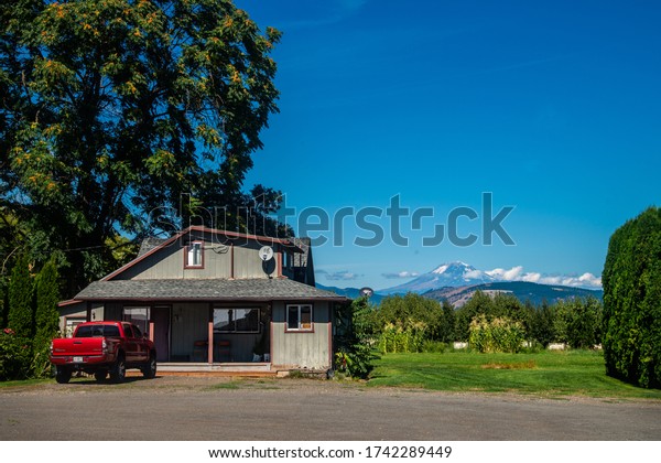 Hood River, Oregon / USA - August\
30, 2019: farmhouse on Fruit Loop overlooking Mount\
Hood.