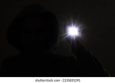 Hooded Burglar. Silhouette Of Thief And Flashlight