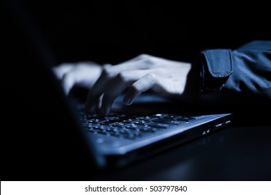 Hooded Computer Hacker Stealing Information With Laptop