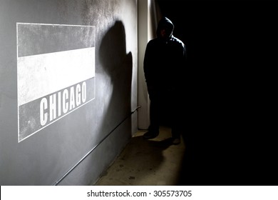 Hooded Hip Hop Rapper Next To Wall Graffiti With Copy Space.  The Man Is Standing In A Dark Alley And A Spray Painted Concrete Wall.