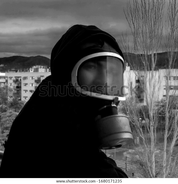 hooded man in a black\
and white gas mask