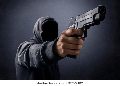 Hooded Man With A Gun In The Dark