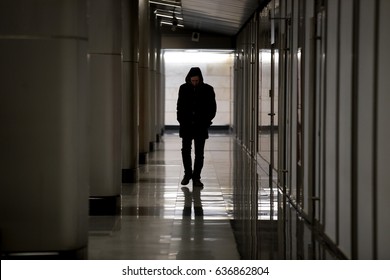 Hooded Sad Man Wearing Black Walking Along Dark Empty Hallway, Looking Down, Lonely Introvert Hiding From The World, Frustrated Homeless Guy Having Deep Depression, Wandering Solitary Outcast