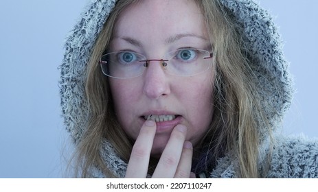 Hooded Woman With A Cringing Look, Being Cold Or Scared. Blond Hair And Green Eyes.