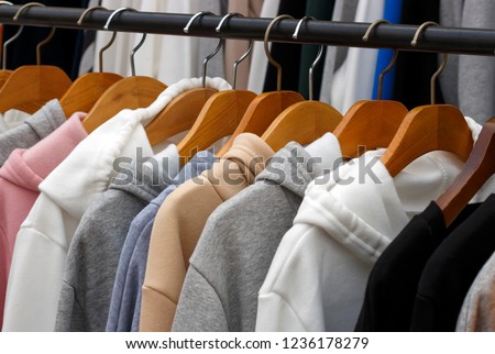 hoodies on hangers in a clothing store, close-up
