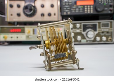 Hoogkerk, Netherlands, November 10, 2021: Tuning capacitor or Rotary Variable Capacitor Variable air capacitor antique radio. In the background different frequency counters, radios or transceivers