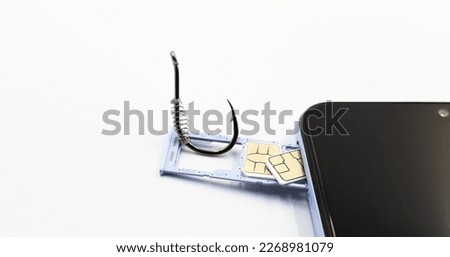 A hook next to the SIM cards of a mobile phone. A hook next to the SIM cards of a mobile phone. Concept of Cyber Attack and Phishing