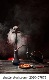 Hookah, bottle of wine and dates on table