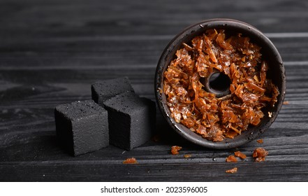 Hookah bowl with tobacco and charcoal for smoking on a dark background. Space for text. Banner
