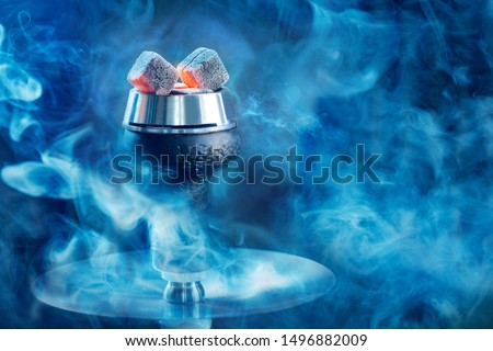 Hookah or shisha hot coals, dark black smoke background.