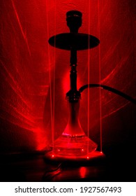 Hookah for smoking that consists of a small container or bowl, where chopped tobacco is burned, attached to a tube ending in a mouthpiece, through which the smoke is inhaled. platform with red laser 