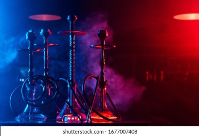 hookahs with shisha bowls and coals on the background of smoke in the restaurant for relaxation with tobacco use