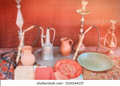 Hookahs In The Shop Of The Ottoman Turks. Turkish Decoration Of The Old Shopkeeper. Vintage Hookahs, Coffee Pots Carpets.