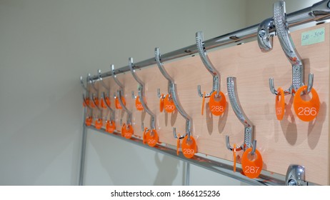 Hooks for clothes with numbers in the empty locker room.