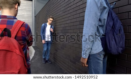 Hooligans threatening weak boy in school backyard, bullying, provoking conflict