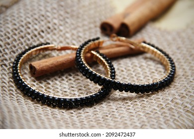 
hoop earrings with black stones close-up on a decorative background