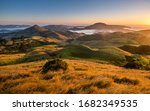 Hoopers Inlet bay and Papanui Inlet Otago Peninsula New Zealand. Beautiful sunrise in Otago district close to Dunedin city. Inlets, sounds, highlands, green hills, meadows, fields, valley with sheep.