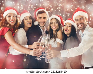 Hooray. Diverse friends clinking with champagne flutes, celebrating together on New Year's Eve party - Powered by Shutterstock