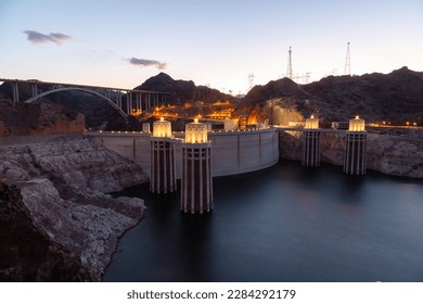 Hoover Dam at sunset in the evening with illuminations without people. Hoover dam, view point. Hoover dam and Lake Mead in Las Vegas area. Large Comstock Intake Towers At Hoover Dam.