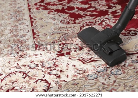 Hoovering carpet with vacuum cleaner, space for text. Clean trace on dirty surface