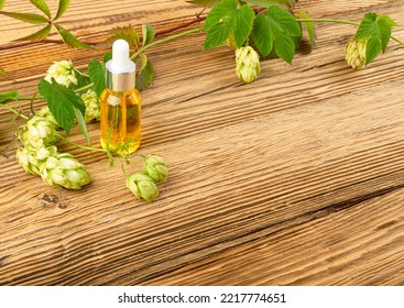 Hop Essential Oil On Wooden Table. Humulus Extraction For Phytotherapy, Hop Infusion, Herb Extract Mockup With Copy Space