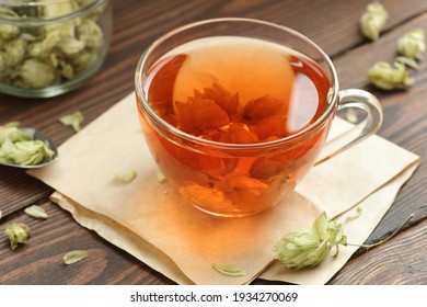 Hop herbal tea with dry herb on wooden table, natural decoction is used against insomnia, depression and for menopause and skin, hair care, closeup, copy space, natural medicine, naturopathy concept - Shutterstock ID 1934270069