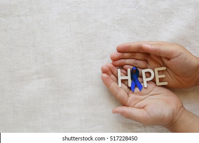 HOPE with Blue ribbon on hands, Colon Cancer, Colorectal Cancer, Child Abuse awareness
