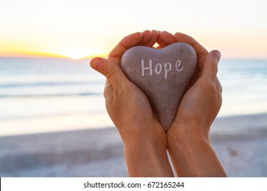 hope concept, hands holding stone with word written on it