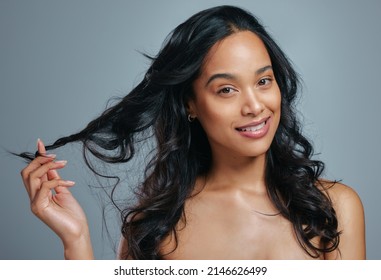 I Hope You Have A Good Hair Day Today. Studio Portrait Of An Attractive Young Woman Posing Against A Grey Background.