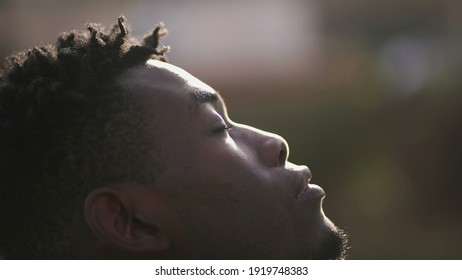 Hopeful black man eyes closed meditating. Contemplative African person