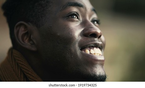 Hopeful black man opening eyes to sky smiling. African man feeling hope and faith - Shutterstock ID 1919734325