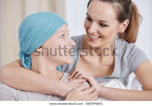 Hopeful cancer woman wearing headscarf, talking\
with friend