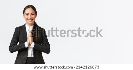 Hopeful glad asian businesswoman in black suit bowing politely and say namaste, greeting clients and smiling friendly. Thankful female manager thanking for help, being grateful, appreciate help