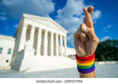 Hopeful Hand Wearing Gay Pride Rainbow Flag Wristband Crossing Fingers For Good Luck Outside The Supreme Court Building In Washington, DC, USA