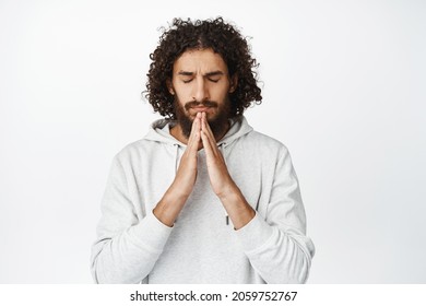 Hopeful Worried Hispanic Man Praying, Pleading God, Hoping For Smth, Standing Over White Background