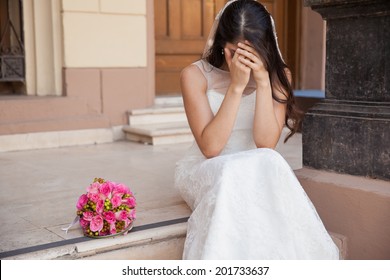 Hopeless bride crying outside a church after being stood up on her wedding day - Powered by Shutterstock