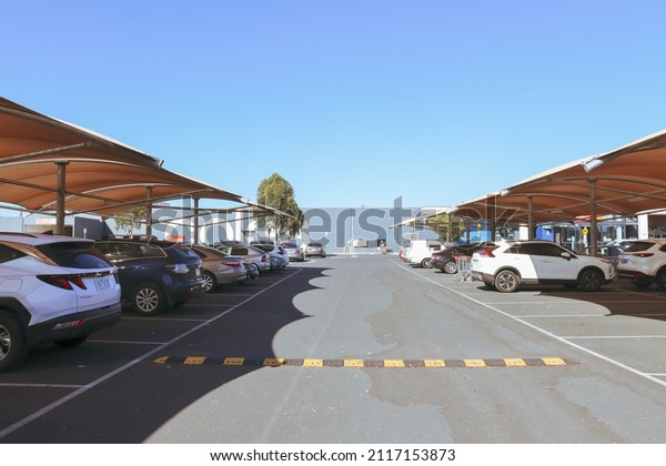 Hoppers\
Crossing, Vic Australia - January 21 2022: Cars parked under shade\
sails in summer at suburban shopping\
centre