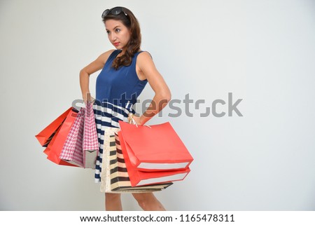 hopping woman holding shopping bags on white background at copy space. Beautiful young mixed race Caucasian