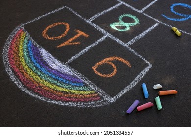 Hopscotch drawn with colorful chalk on asphalt outdoors - Shutterstock ID 2051334557