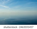 Horizon over blue sea and sky with red flag