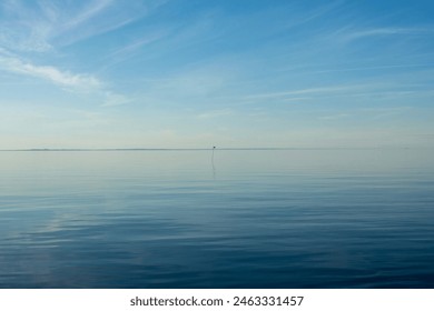 Horizon over blue sea and sky with red flag - Powered by Shutterstock