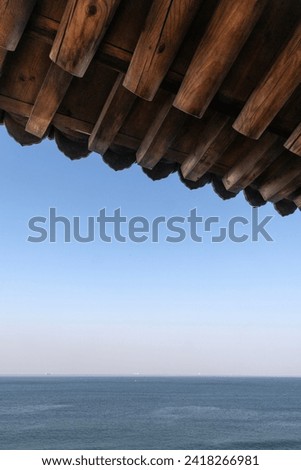 horizon over the sea below the traditional eaves of Korean pavilion on a sunny day