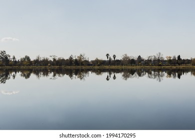 Horizon Reflected In Lake With A Single Cloud