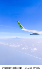 Horizon View Taken From An Airplane. Mountain Top Seen Far Away. Slightly Cloudy Bright Blue Sky. Coastline Seen From Above.