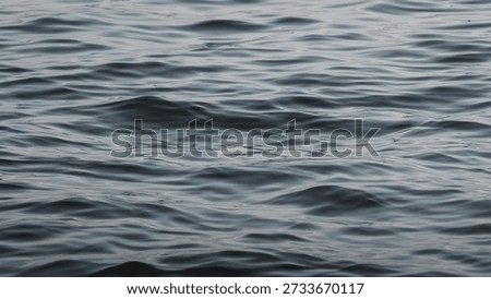 Horizontal abstract close-up texture of dark blue water ripples. Calm sea waves surface pattern background. Deep ocean liquid detail