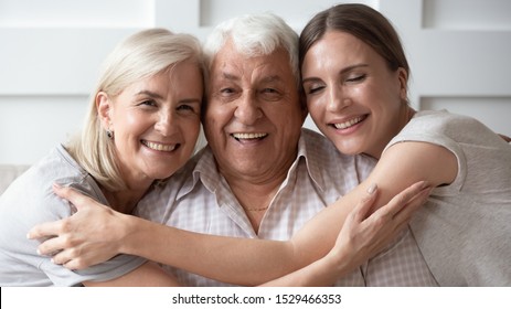 Horizontal banner close up image of three-generation family portrait happy beautiful faces, adult daughter embracing 80s father 60s middle-aged mother closest relatives people, good relations concept
