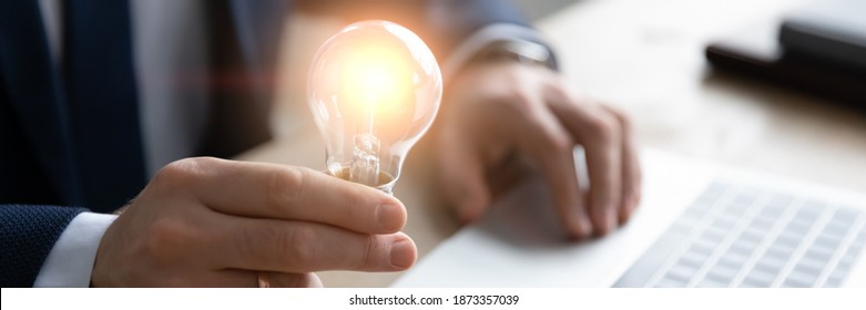 Horizontal banner close up successful businessman holding light bulb, inspiration and creativity concept, innovative business startup idea, motivated executive or boss working on creative project - Shutterstock ID 1873357039