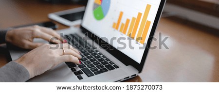 Horizontal banner close-up workplace with computer laptop and Histograms representation on pc screen with woman hands typing. Growth, analysis, tele working concept.