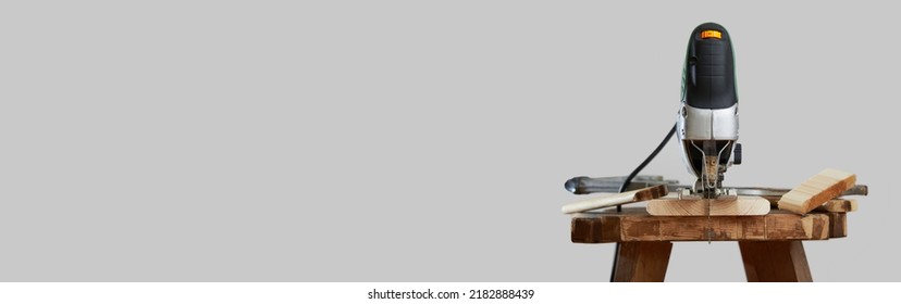 Horizontal banner of electric jigsaw on gray background. Woodworking power tools. Photo with copy space. - Shutterstock ID 2182888439