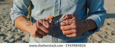 Horizontal banner or header Close-up unrecognizable man holding a pocket knife.